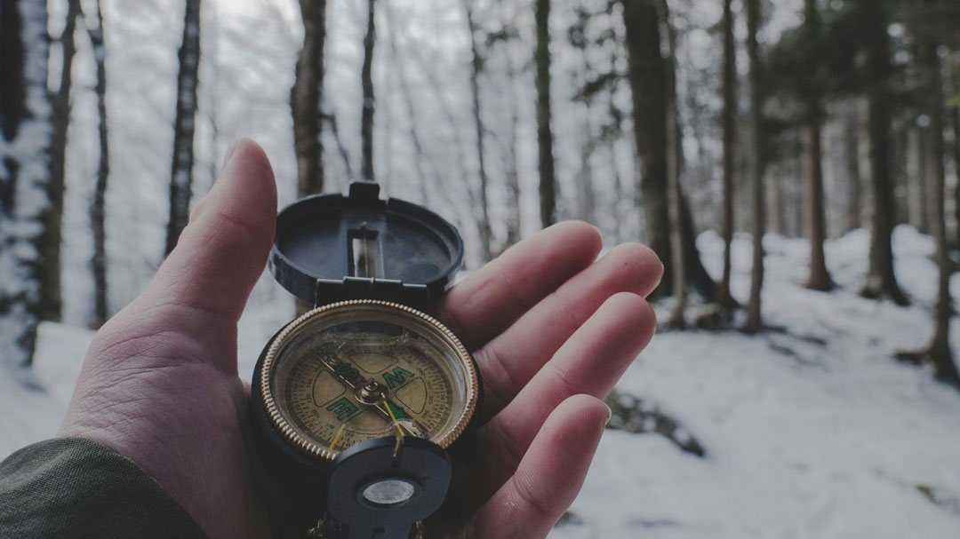 Hand holding a compass. Photo by Tobias Aeppli